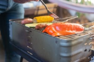 Corn roasts on backyard grills at sunset
